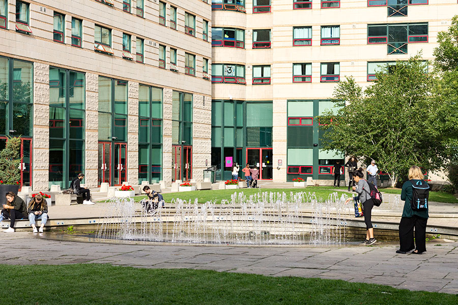 An exterior view of Pitman Hall, including the water fountain in front of the building