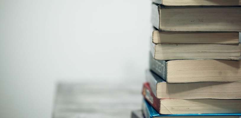 Pile of books sitting on a desk