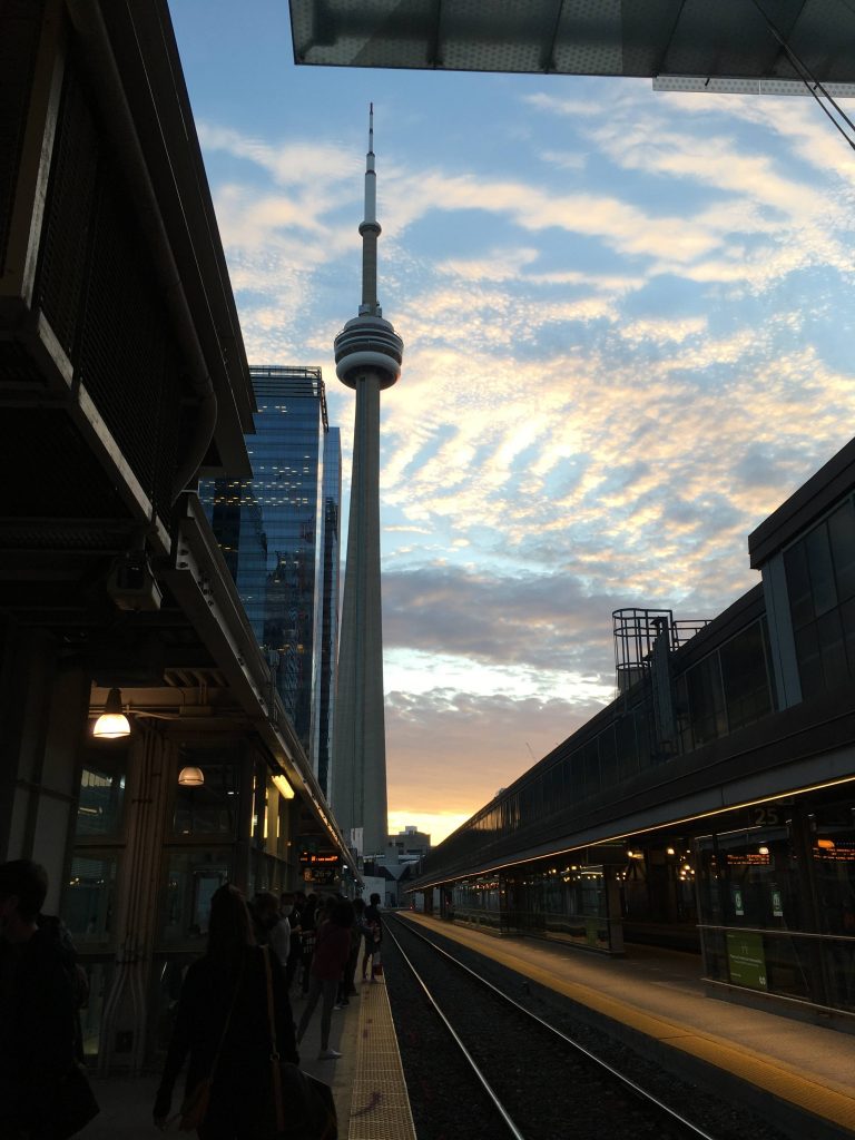 CN Tower in the background while on the GO Station platform