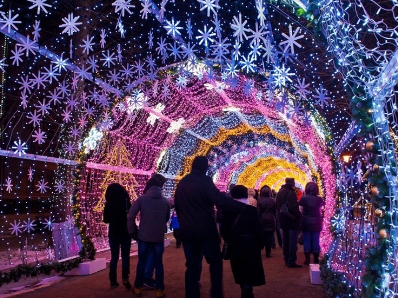 toronto lights festival, a family going through a tunnel of twinkle lights and snowflakes