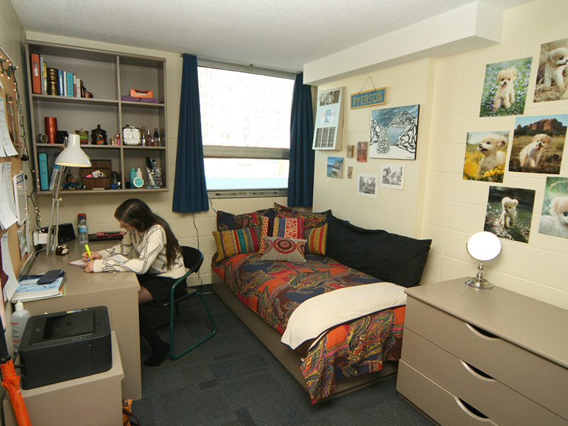 A student sits at her desk in her residence room in Pitman Hall.