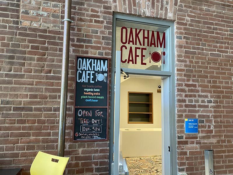 The entrance to Oakham Café among a brick wall inside of the Student Campus Centre.