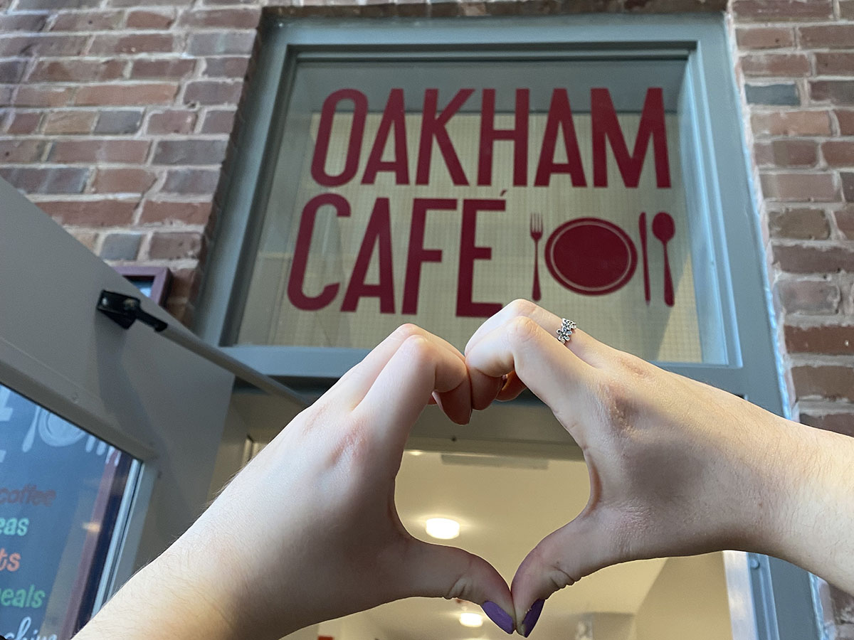 Hands making a heart in front of the entrance to Oakham Café.