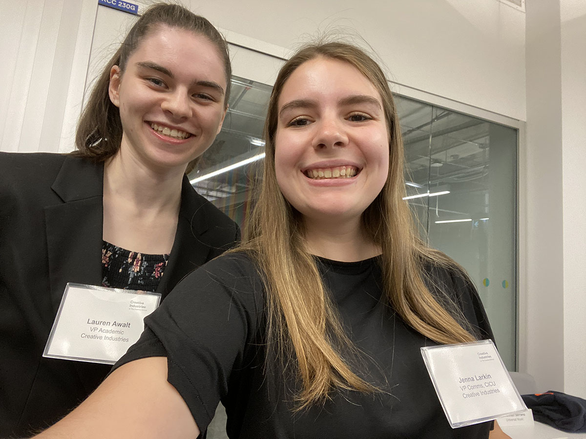 Jenna and Lauren take a selfie at a CICU event while wearing name tags with their names and CICU roles.