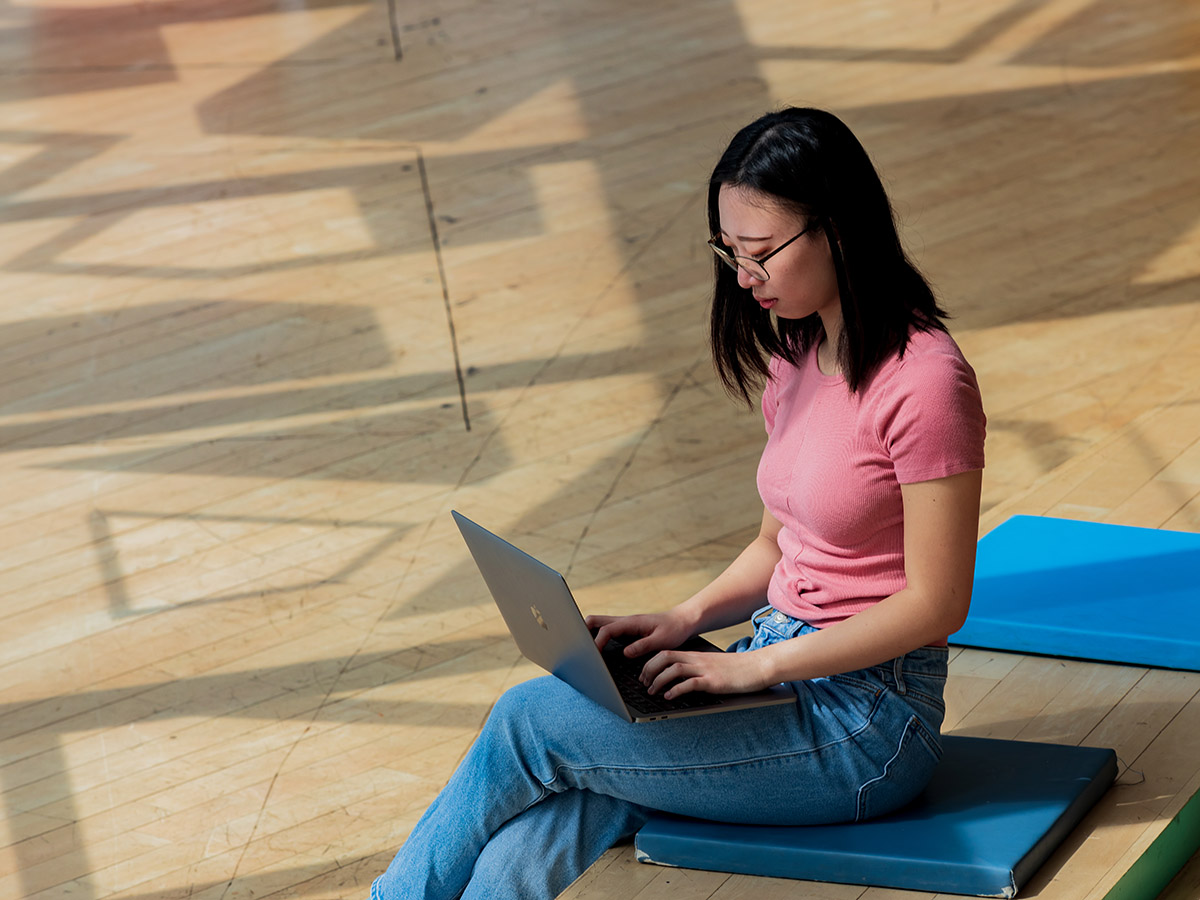 A student works on her laptop on "The Beach" floor of the Student Learning Centre.