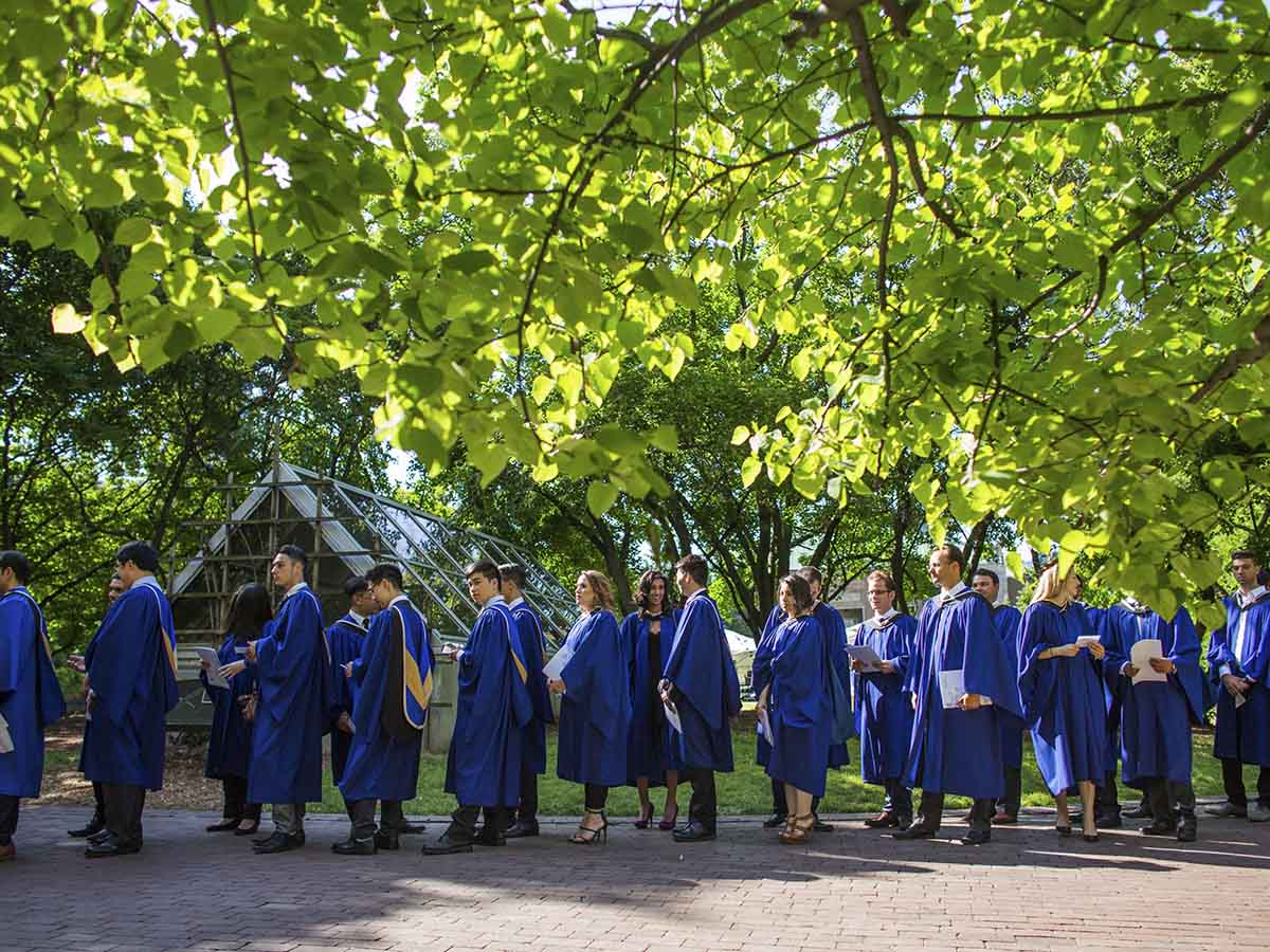 A group of students stand in their convocation gowns in Kerr Quad.