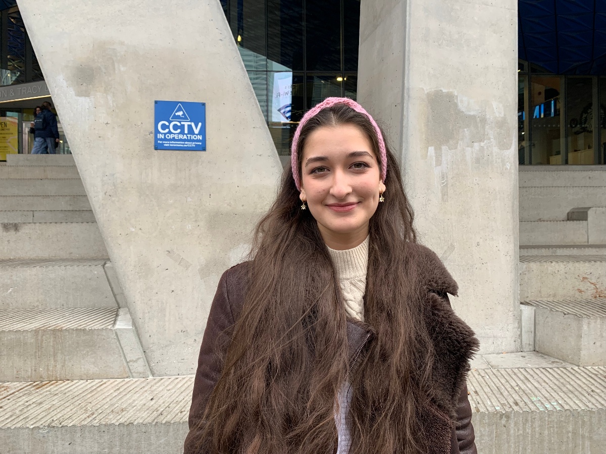 Ayshat is smiling standing outside of the Student Learning Centre. 