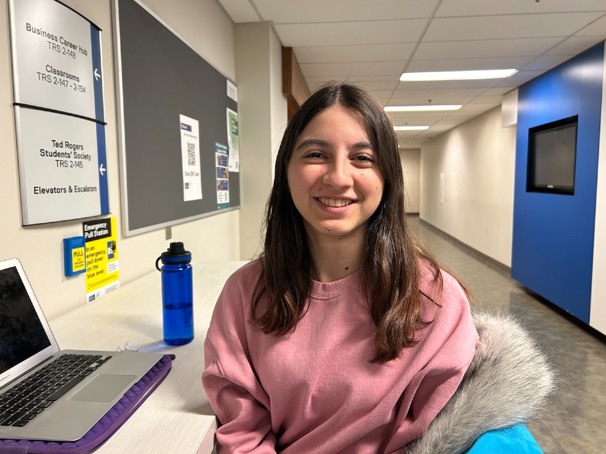 Dimitra cheerfully smiles in the hallway of the Ted Rogers building.