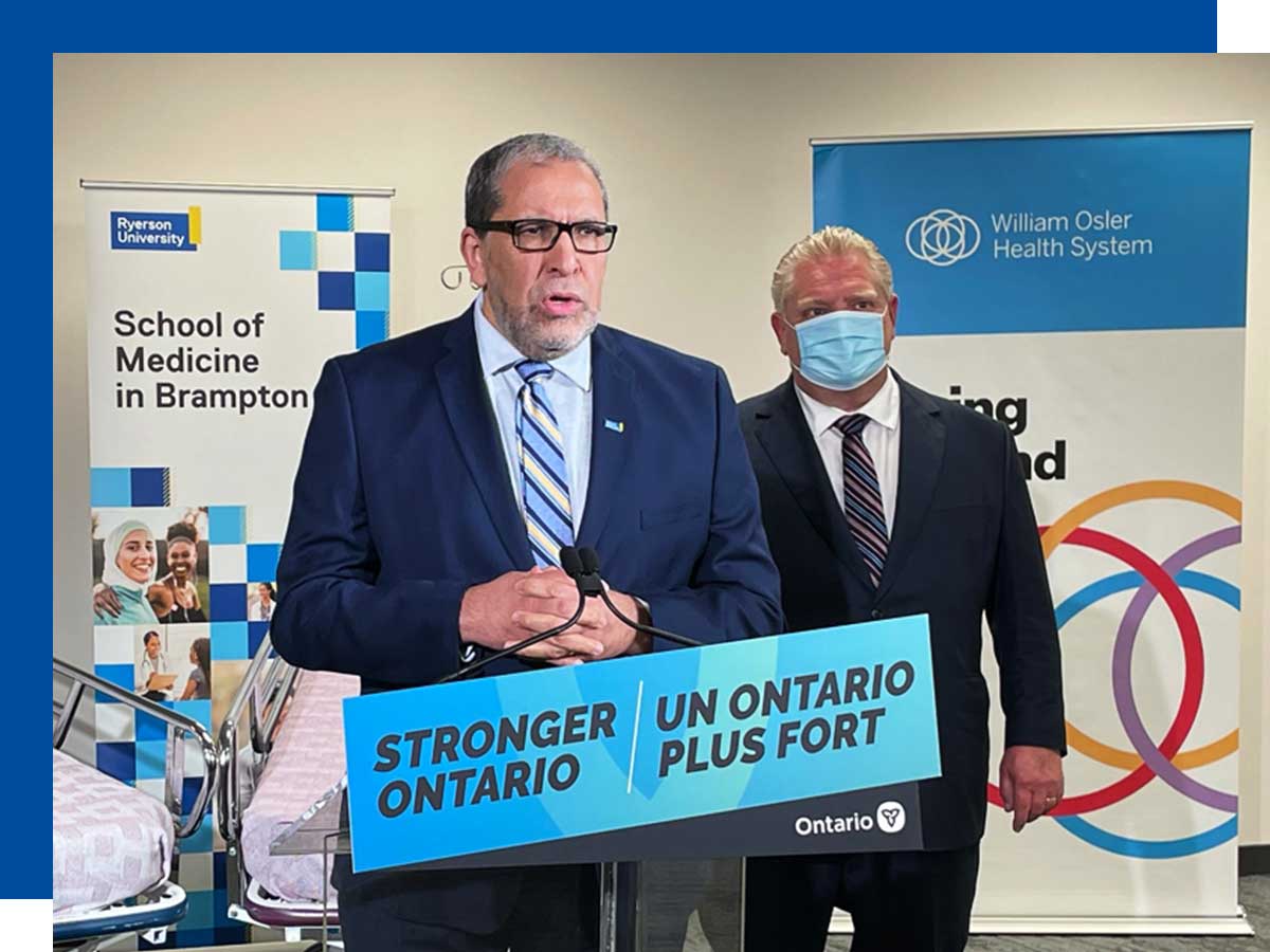 Mohamed Lachemi speaks at a press conference with Premier Doug Ford in the background.