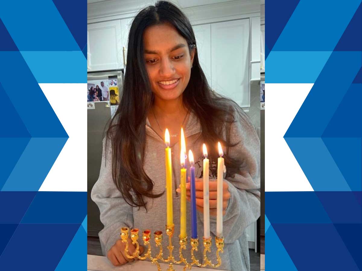 Noam Kehimkar lighting Hanukkah candles