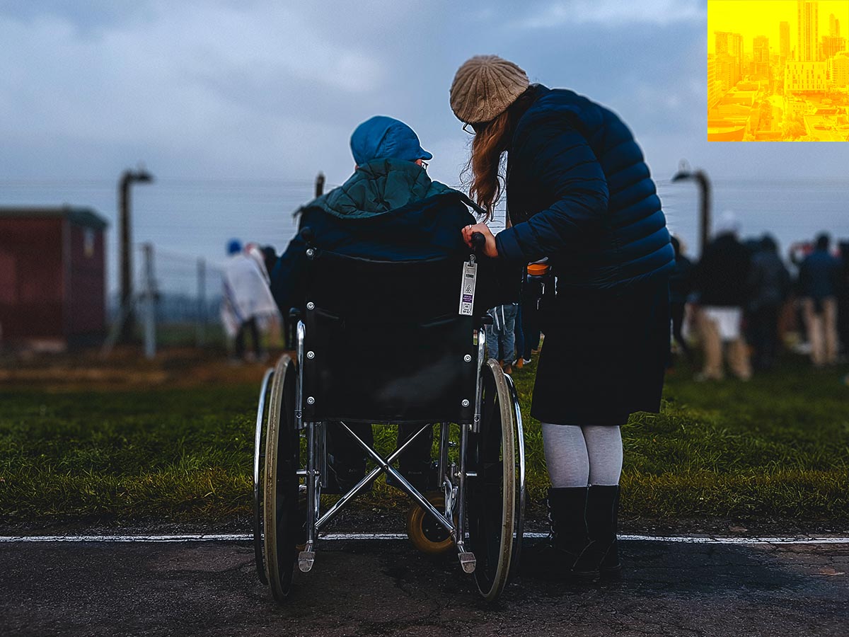 Person in a wheelchair speaking with someone standing