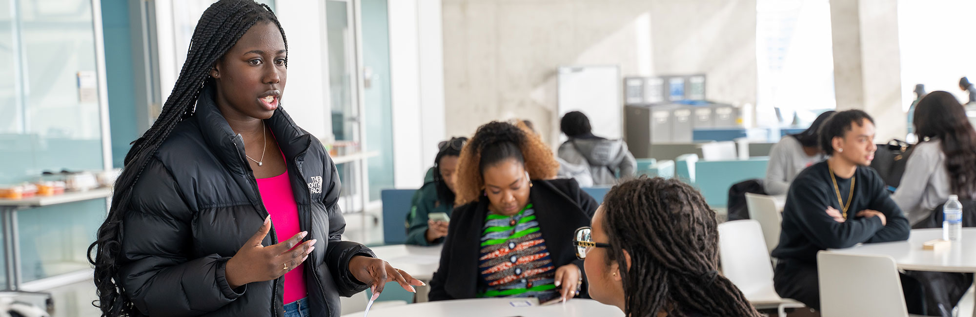 Two Black students at a TMU event discussing how the BSSE is a vital resource offering information on campus events, clubs and organizations.