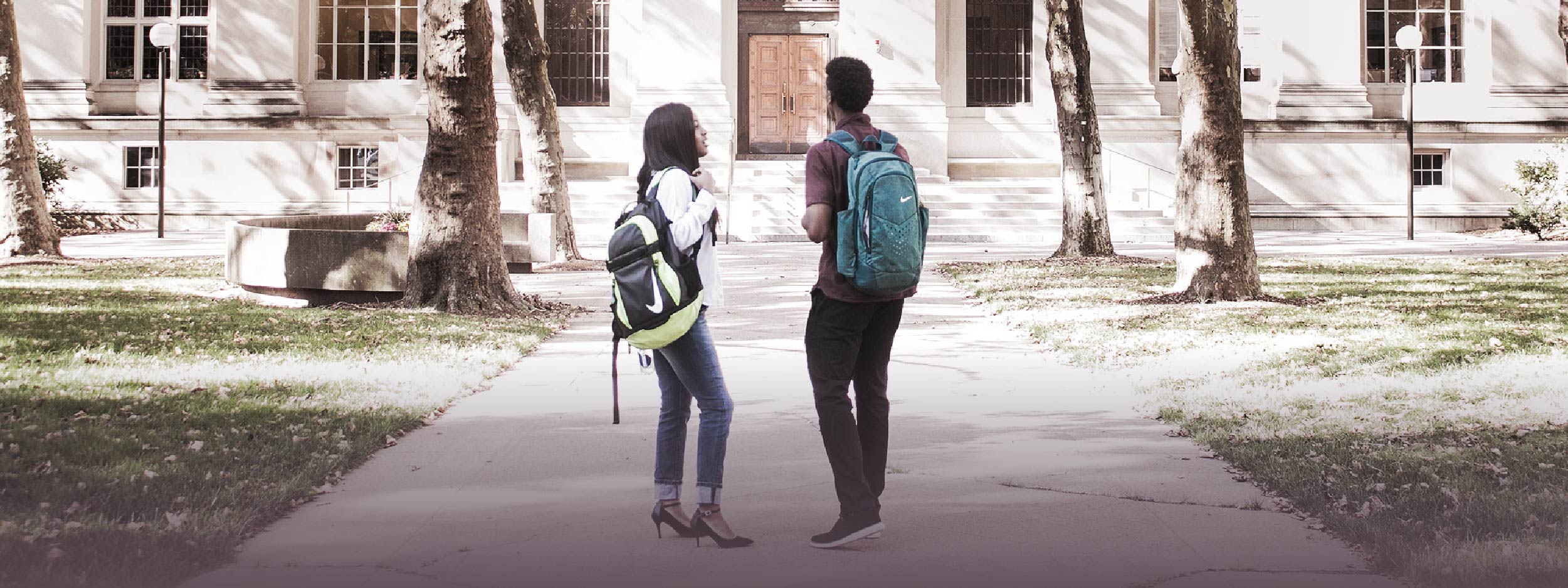 Two post-secondary students standing outside of school building