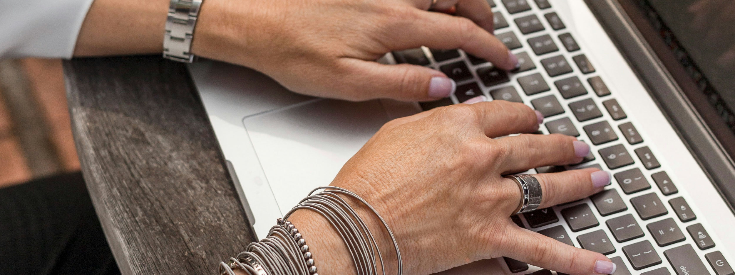 Hands typing on a laptop keyboard