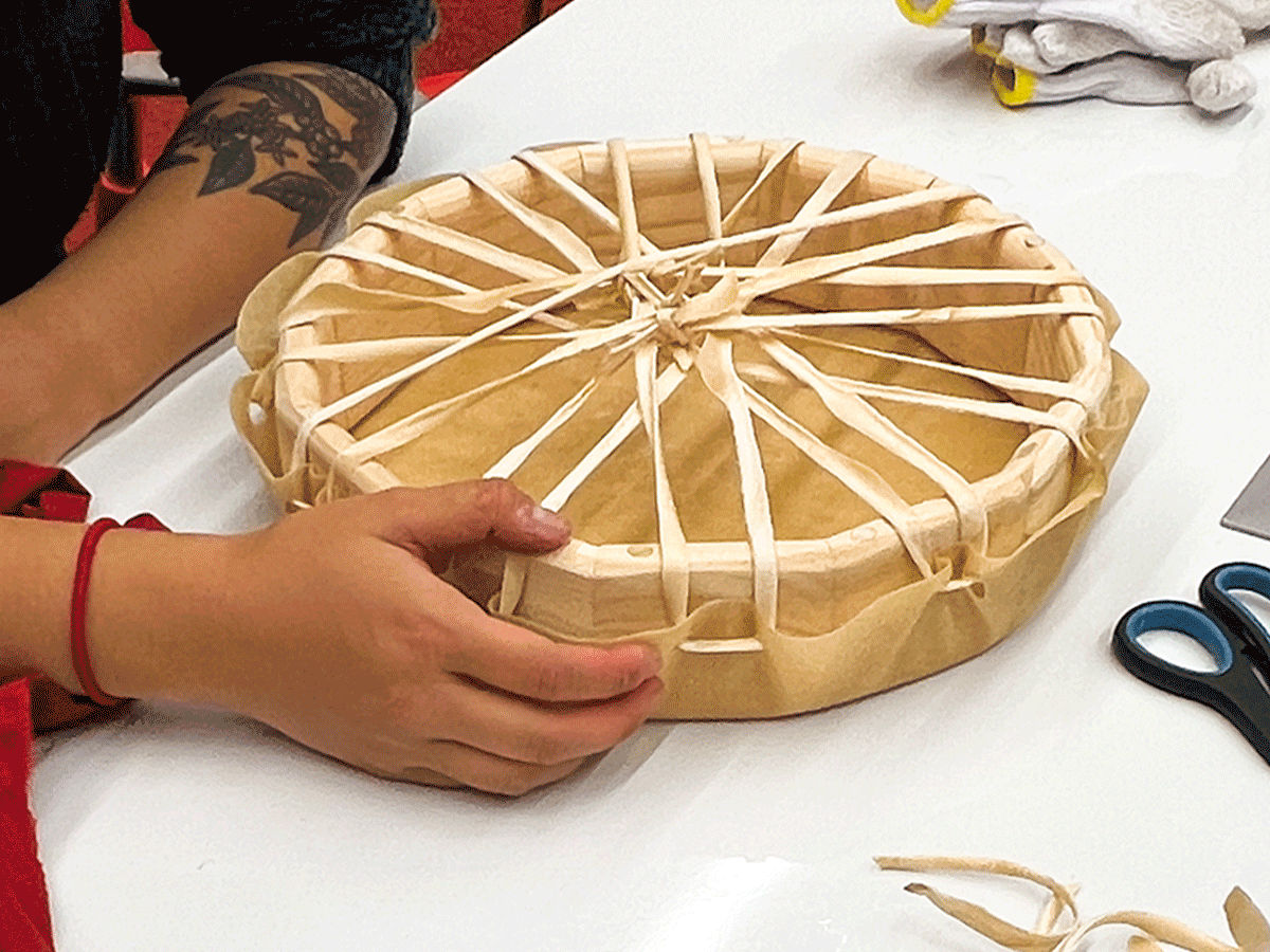 Person making indigenous drum