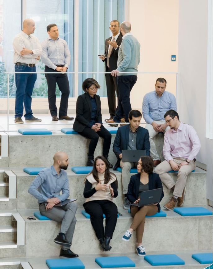 Researchers discussing information shown on a laptop