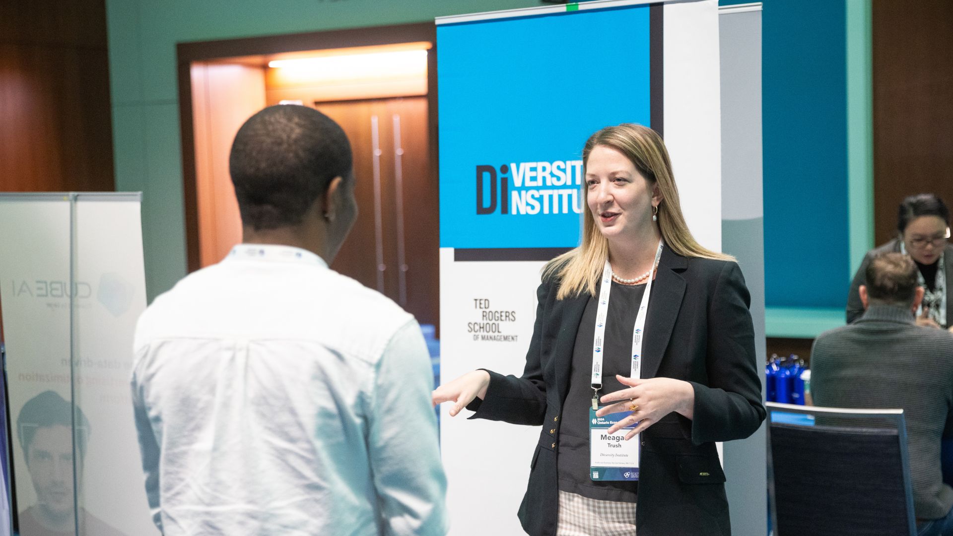 Two business professionals converse at a conference. 