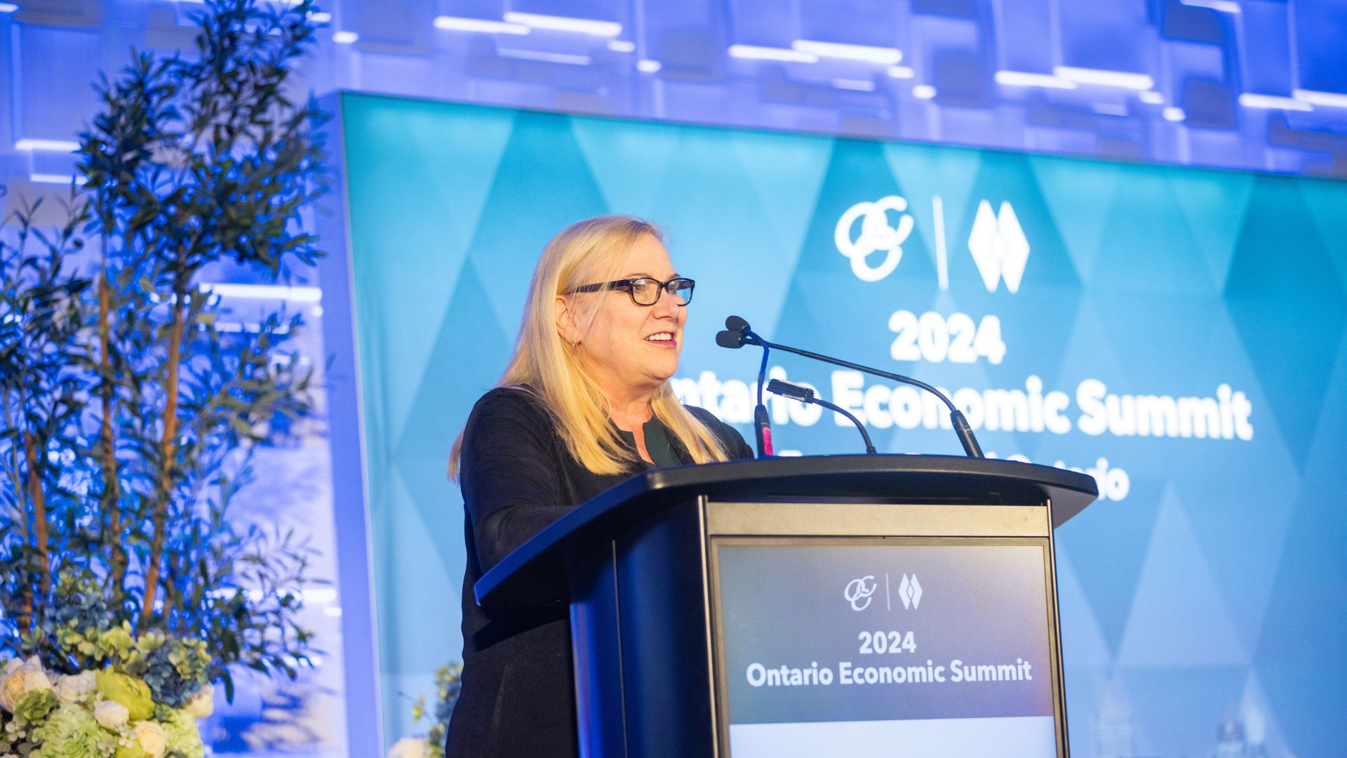 A woman is presenting at a podium.