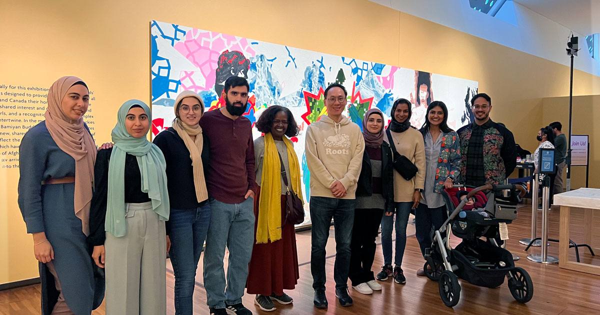 A diverse group of ten Muslim community members and friends at a gallery exhibit