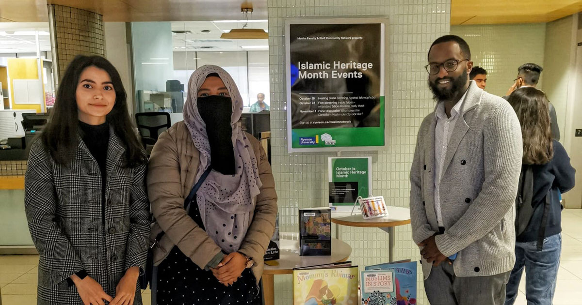 Muslim community members at the TMU Libraries next to books to honour Islamic Heritage Month