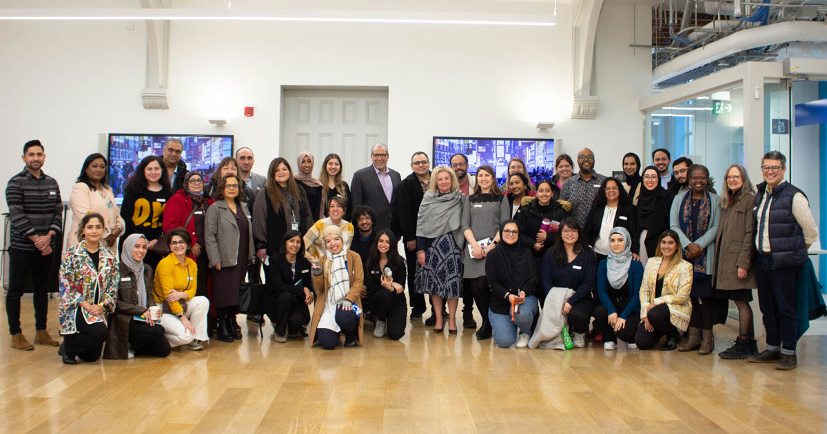 A diverse group of TMU students, faculty and staff gather at an event.