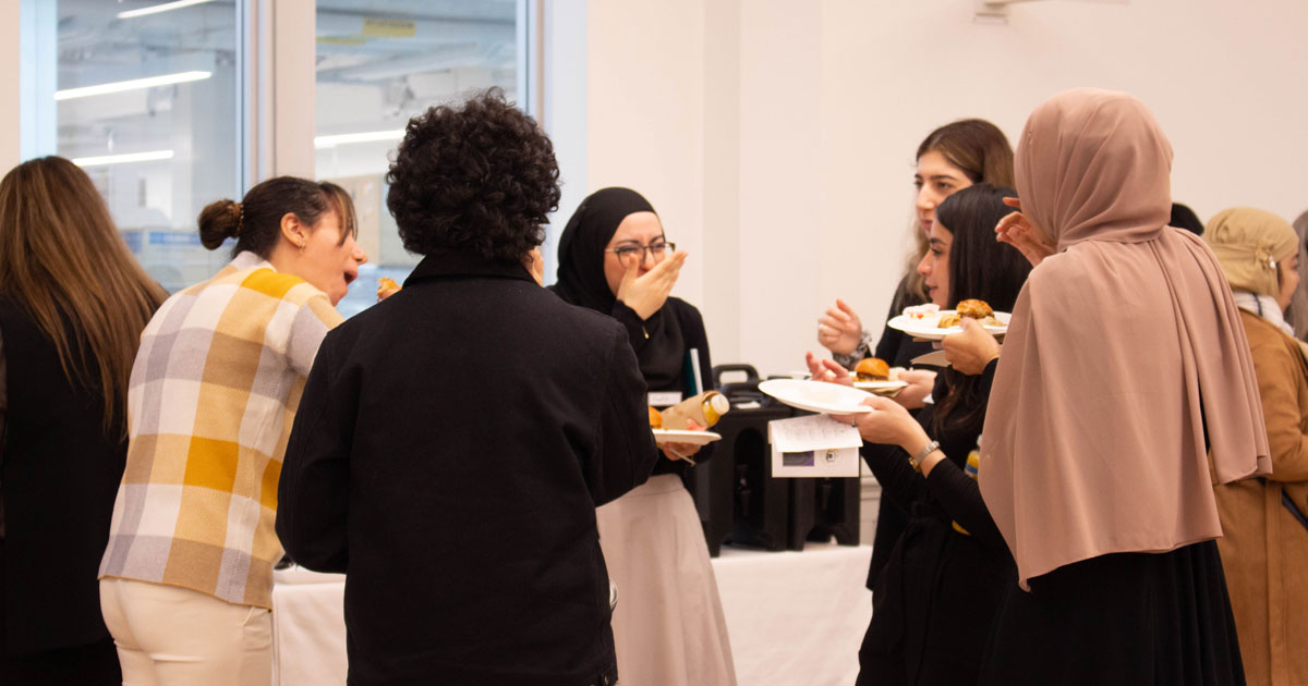 A group of Muslim community members eat and enjoy conversation