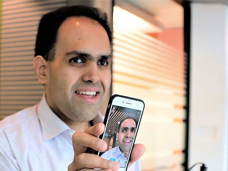 Saqib Shaik holding a photo that has an image of them