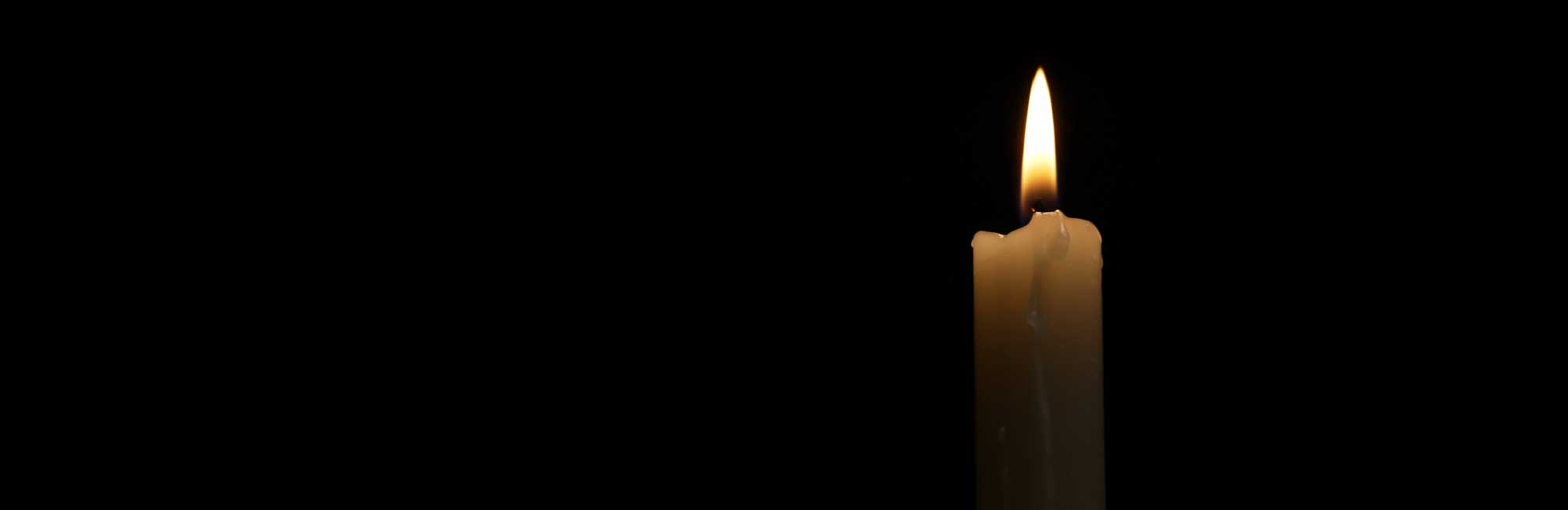 A lit candle, symbolizing remembrance and reflection for the National Day of Remembrance and Action on Violence Against Women.