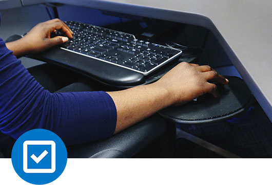 A personâs hands set up correctly at a work station with a mouse and keyboard.