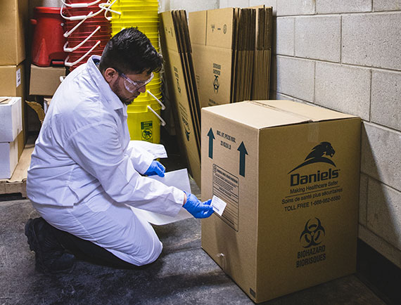 A label being applied to a box containing hazardous waste.