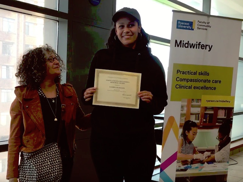 Kambili Husbands holding student award at the Midwifery Education Program student awards ceremony