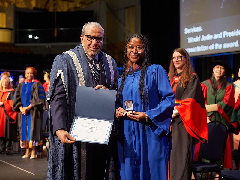 President Mohamed Lachemi presents the TMU Gold Medal Award and Board of Governors Student Leadership Award to Jodie Laborde at convocation on June 11, 2024