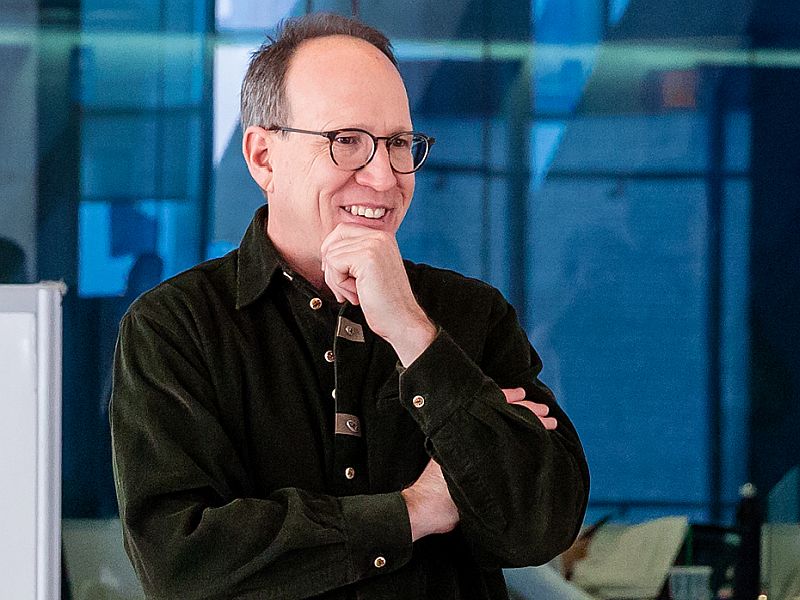 Professor Steven Gedeon smiles with hand on chin