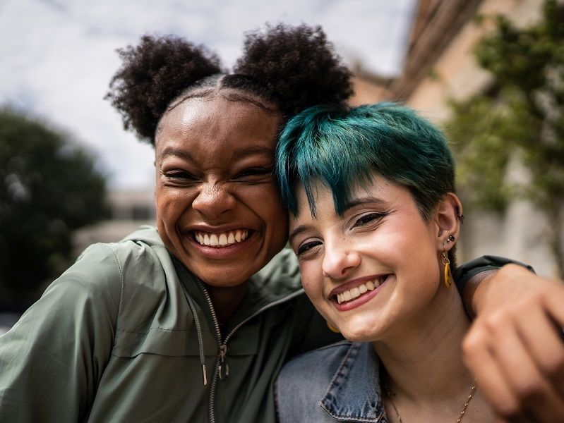 Portrait of friends embracing in the street