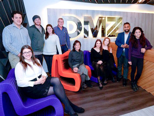 Group in front of DMZ sign. Kimel Family Campus Linked Accelerator Fund award winners pose for a photograph with the Kimel family. (from l to r) Aly Burch and Alejandro Saettjone from uBioDiscovery, Michael Kimel, Samantha Kimel , Warren Kimel, Debbie Kimel, Stephania Stefanakou and team member, Geevith Rubakumar from ParDONE and friend.