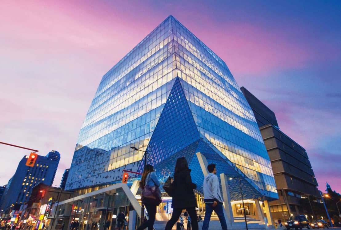 Student Learning Centre in gold and blue against pink and purple sky at dusk