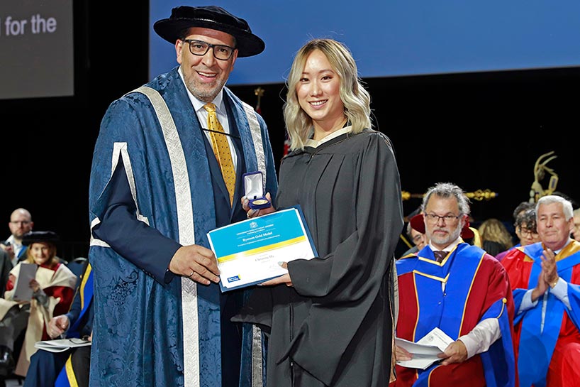 Christina Ma accepts the Toronto Metropolitan University Gold Medal from President Mohamed Lachemi