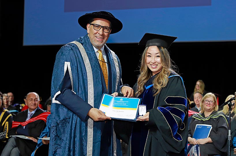 Dr. Jenny Jing Wen Liu accepts the Toronto Metropolitan University Gold Medal from President Mohamed Lachemi