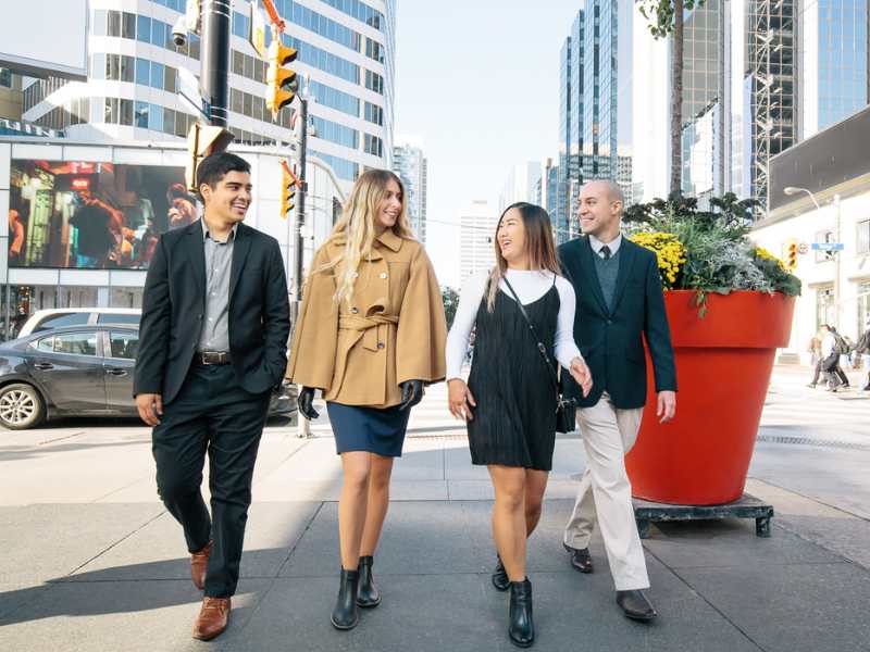 Four students walking in Yonge and Dundas square