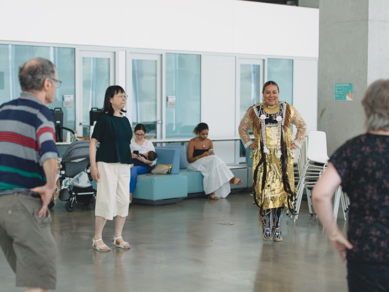 Abby Carpenter wears regalia as she teaches Pow Wow dancing to community members.