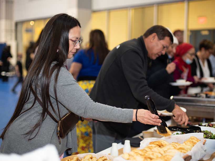 Community members serving themselves food at a buffet