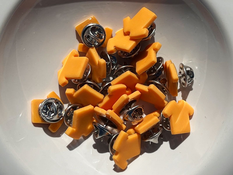 Small orange shirt pins made of clay.