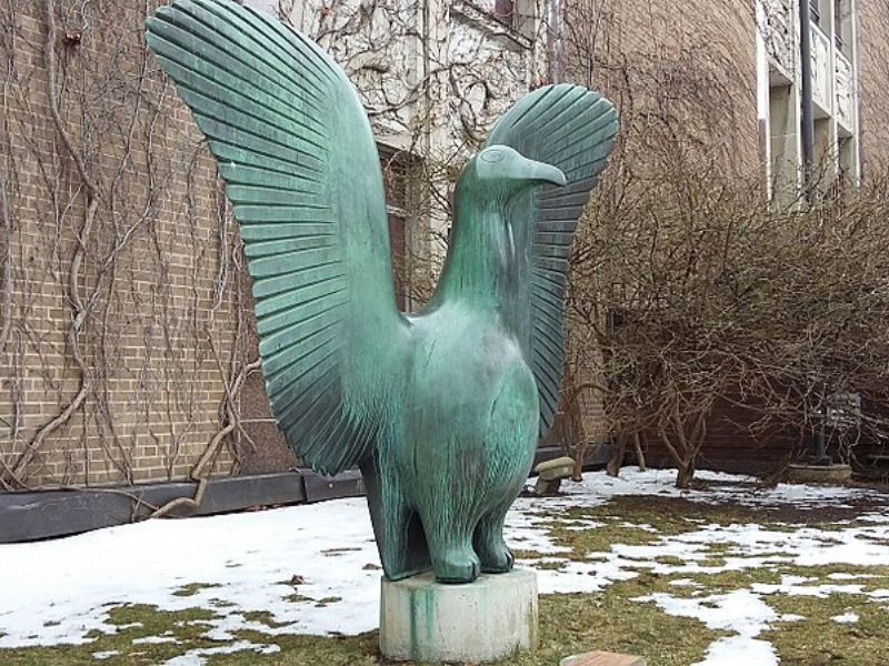 A large bronze bird sculpture with its wings outstretched