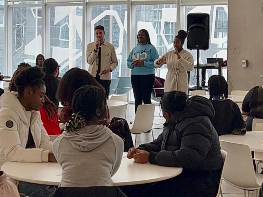 Isioma and two students are presenting to a group of students in the Student Learning Centre.