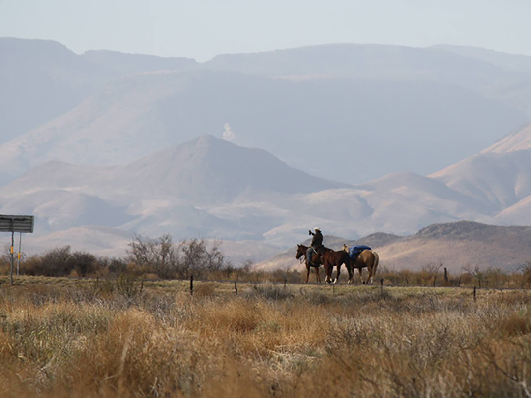 Filipe Masetti Leite riding horseback in the foreground stunning mountains in the background. 