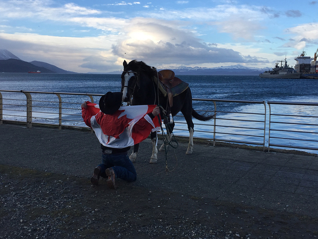 Filipe Masetti Leite at the end of the South American Continent with his horse and a Canadian flag. 