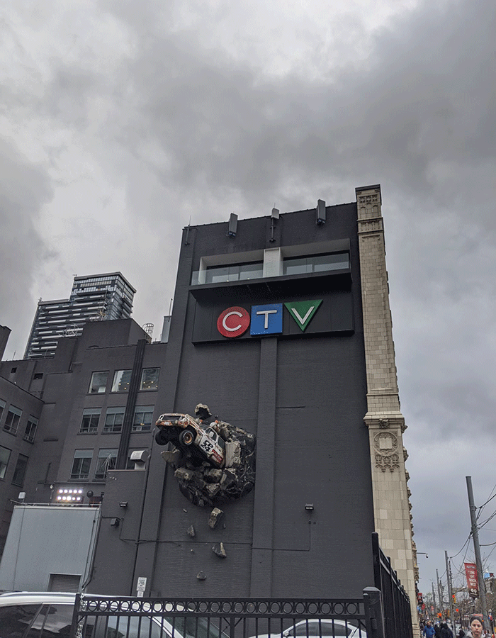 Profile shot of the icon CTV building with a sculpture of a car breaking through the buildings wall.