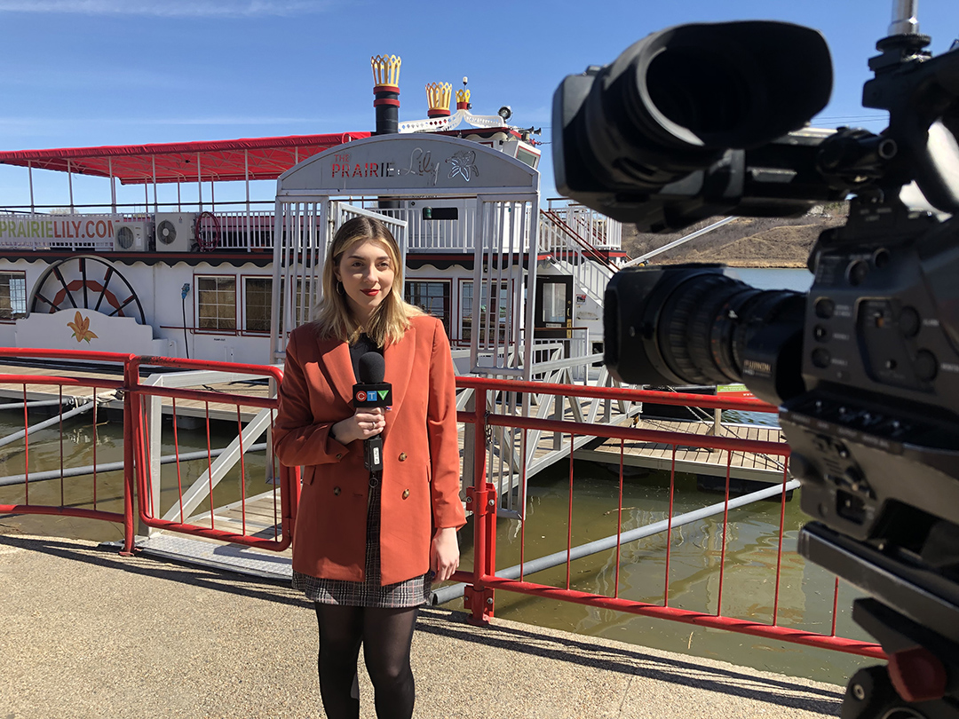 Nicole Di Donato filming a stand up in front of a boat. 