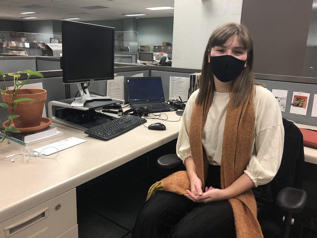 Maggie Macintosh wearing a mask at her desk at the Winnipeg Free Press.