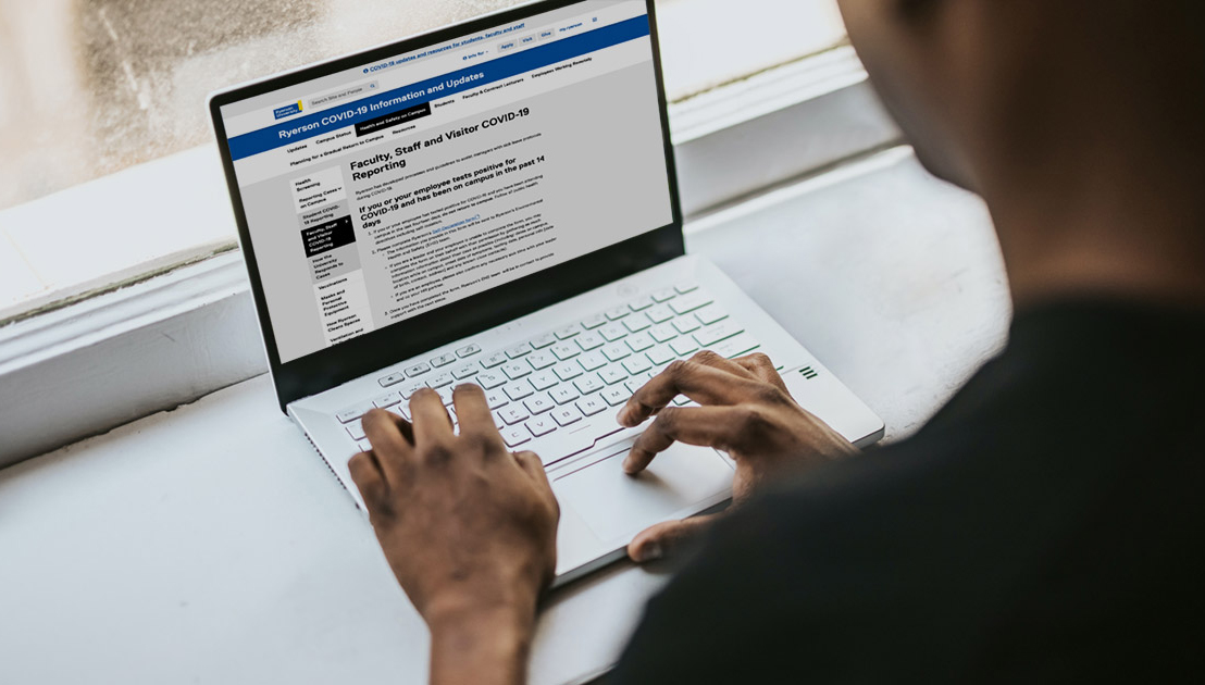 A student checking out the Ryerson COVID information page on a laptop. 